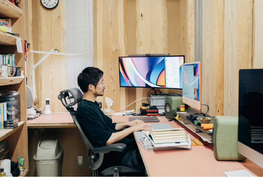 １階 書庫兼仕事場で編集作業をする川田さん